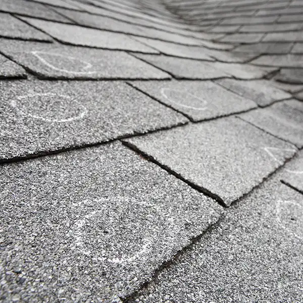 Close up of a residential roof with white circles to mark storm damage