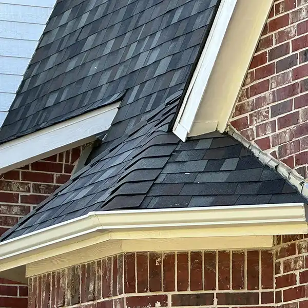 Close up of a residential roof with new black shingles installed by Kime Construction